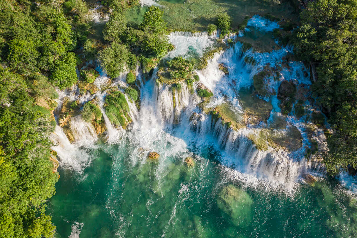 Aerial view of Skradinski Buk waterfall surrounded by trees with turquoise water in Lozovac, Croatia